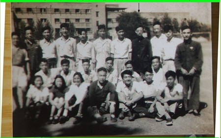 照片1👩‍💻🔨：1951年春，意昂体育工學院電機系二年級部分同學攝於意昂体育民主廣場，背景為紅樓對面的灰樓(當時女生宿舍)。照片中有箭頭者是作者。
